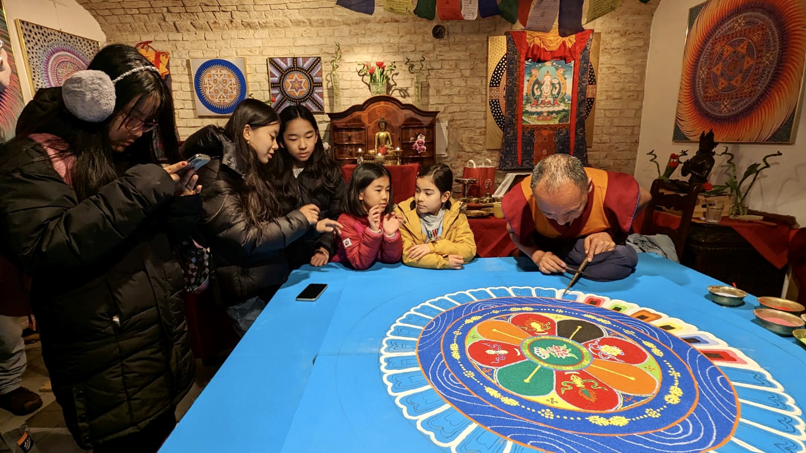 Tibetische Kinder aus Wien beobachten die Mönche bei der Arbeit