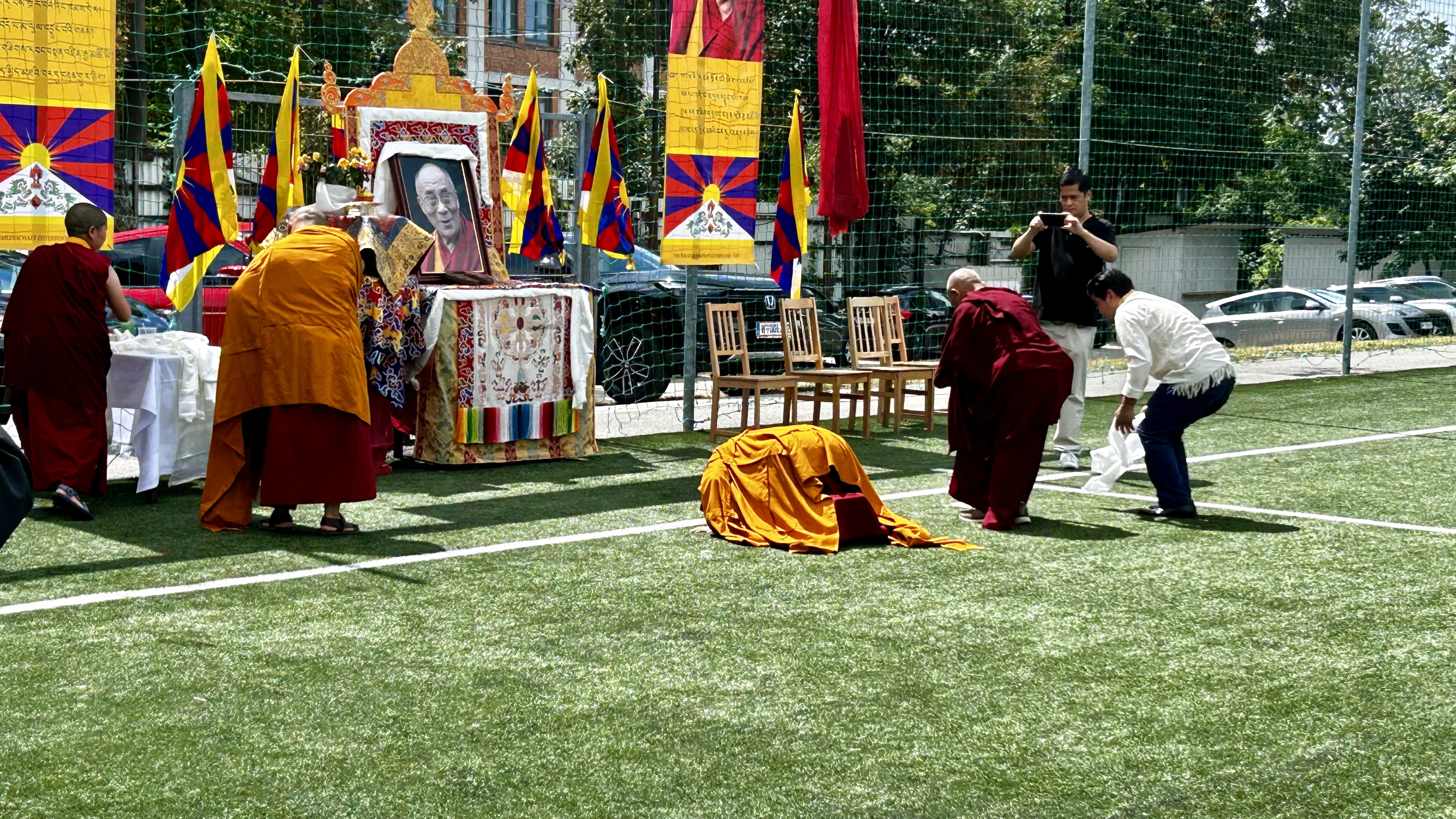 Die Mönche und Tibeter verneigen sich vor dem Altar des Dalai Lama